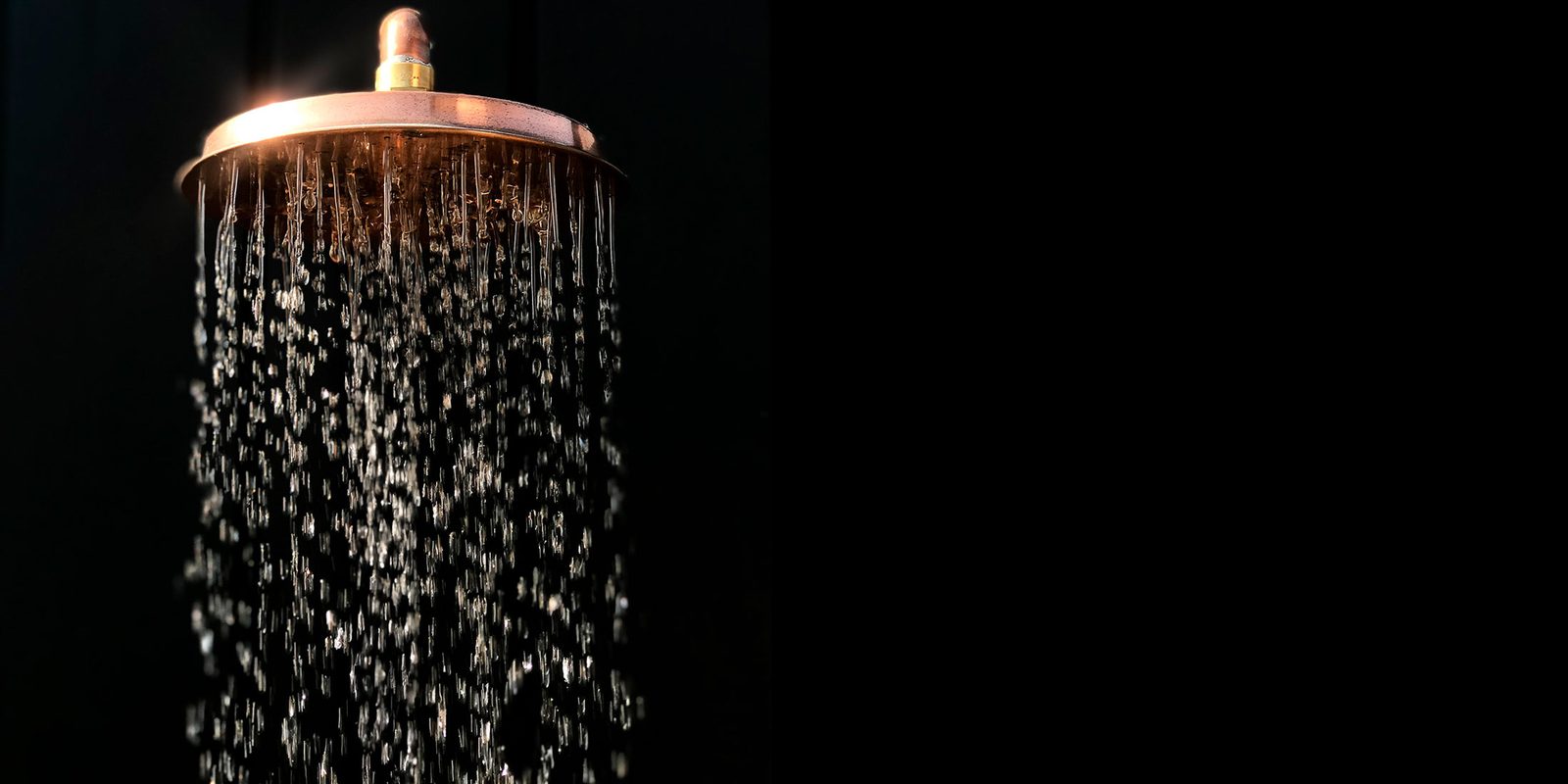 Rociador de cobre con agua cayendo — ducha exterior artesanal